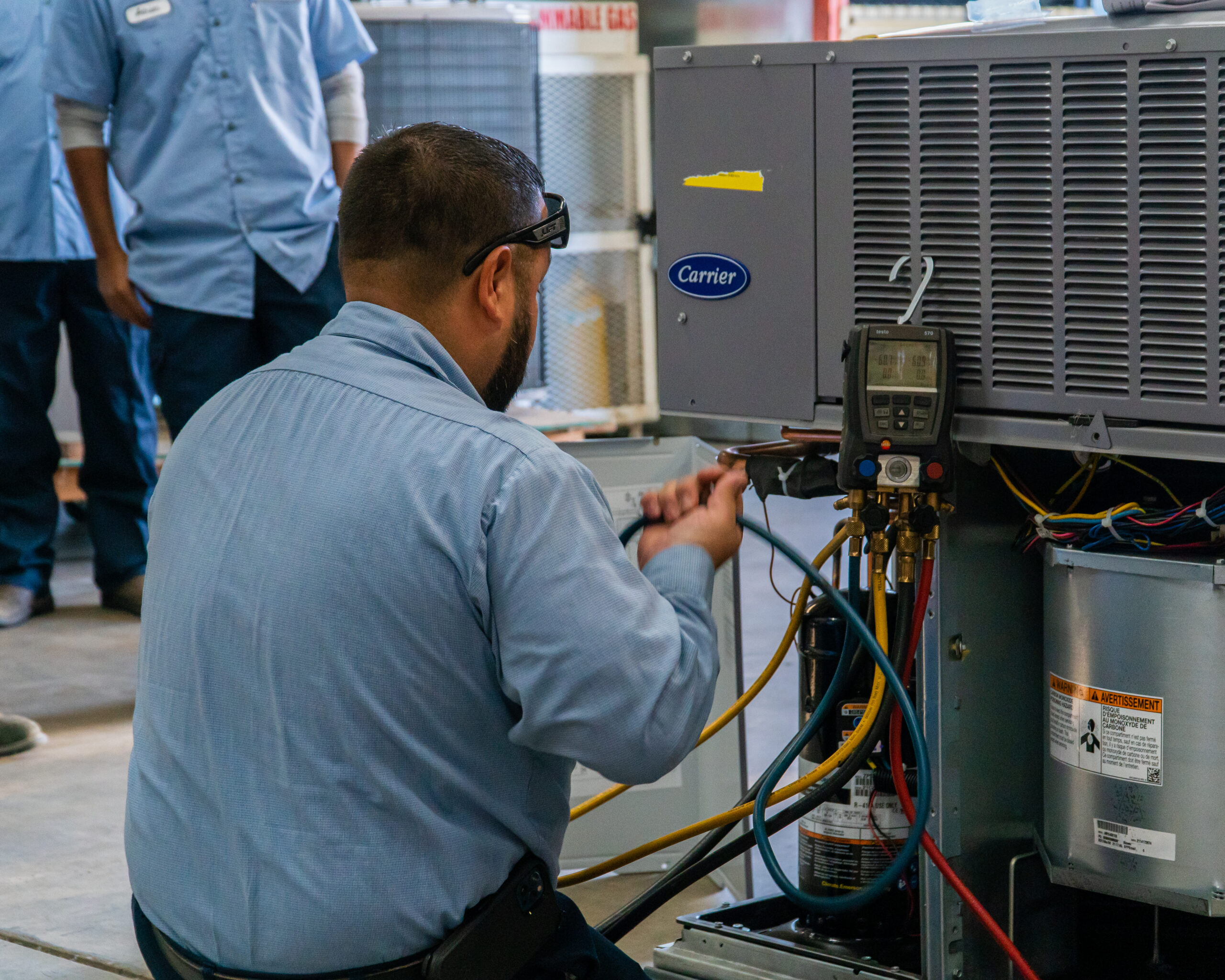 Technician servicing a packaged HVAC unit in Fresno
