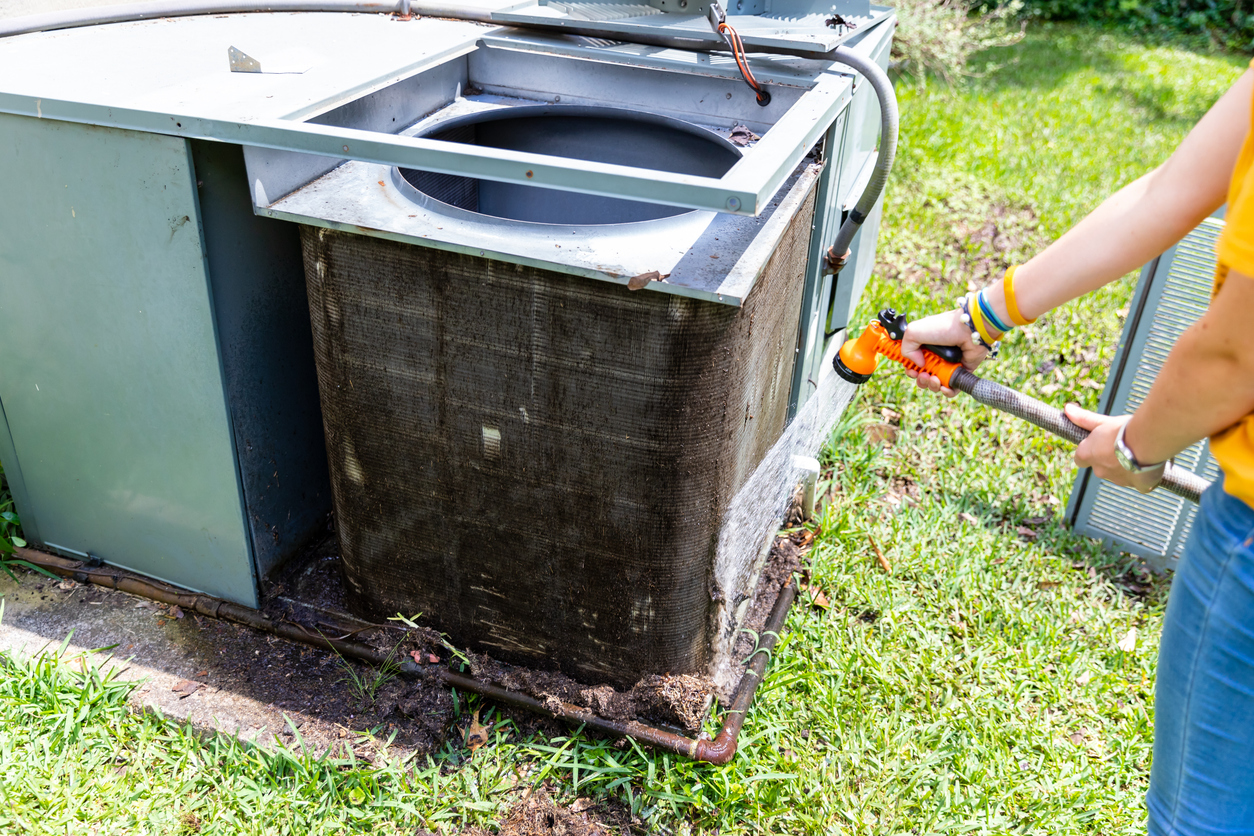 Dirty AC condenser unit covered in debris
